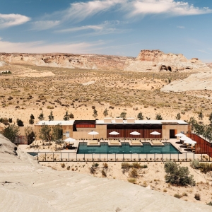 a house in the middle of a desert with a pool.