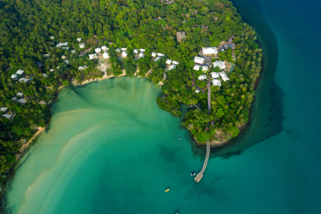 an aerial view of a tropical island with a dock.