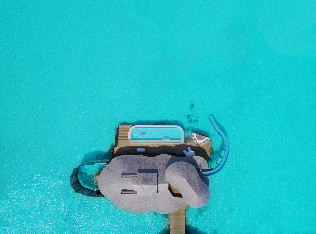 an aerial view of a pool with a lounge chair.