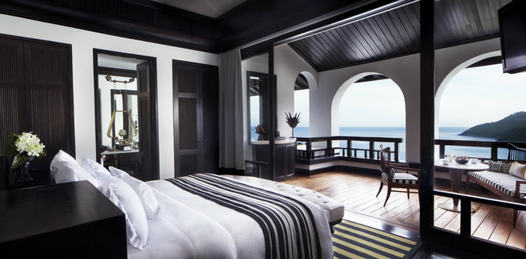 a bedroom with a balcony overlooking the ocean.