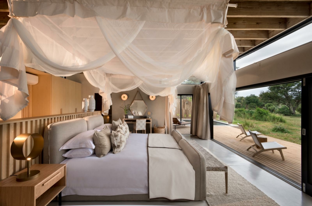 a bedroom with a canopy bed and a large sliding glass door.