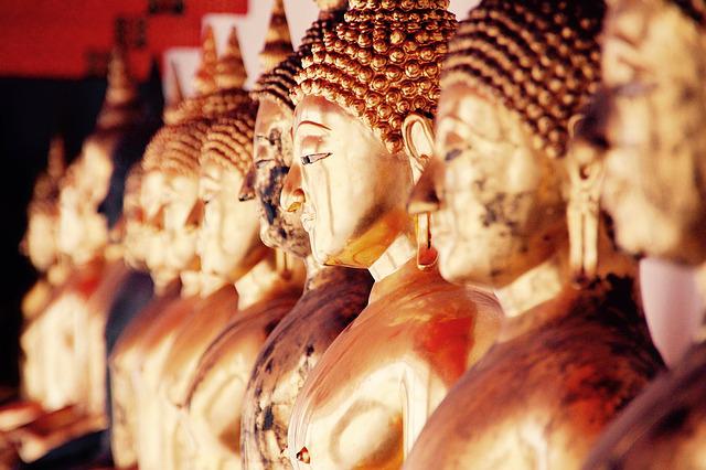 a row of buddha statues sitting next to each other.